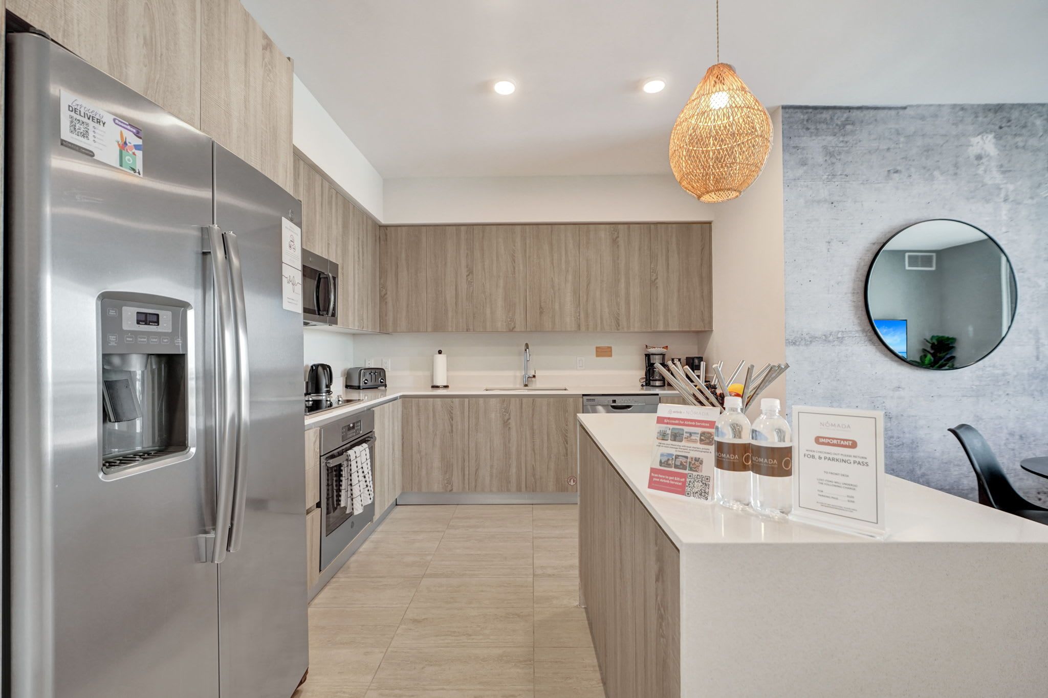 Una cocina moderna con un refrigerador de acero inoxidable, horno empotrado y dispensador de agua.