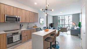 Een moderne keuken met een centraal eiland, roestvrijstalen apparatuur en een eetgedeelte met uitzicht.