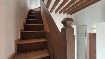 Una escalera de madera con un vidrio en la parte superior que da a una habitación.