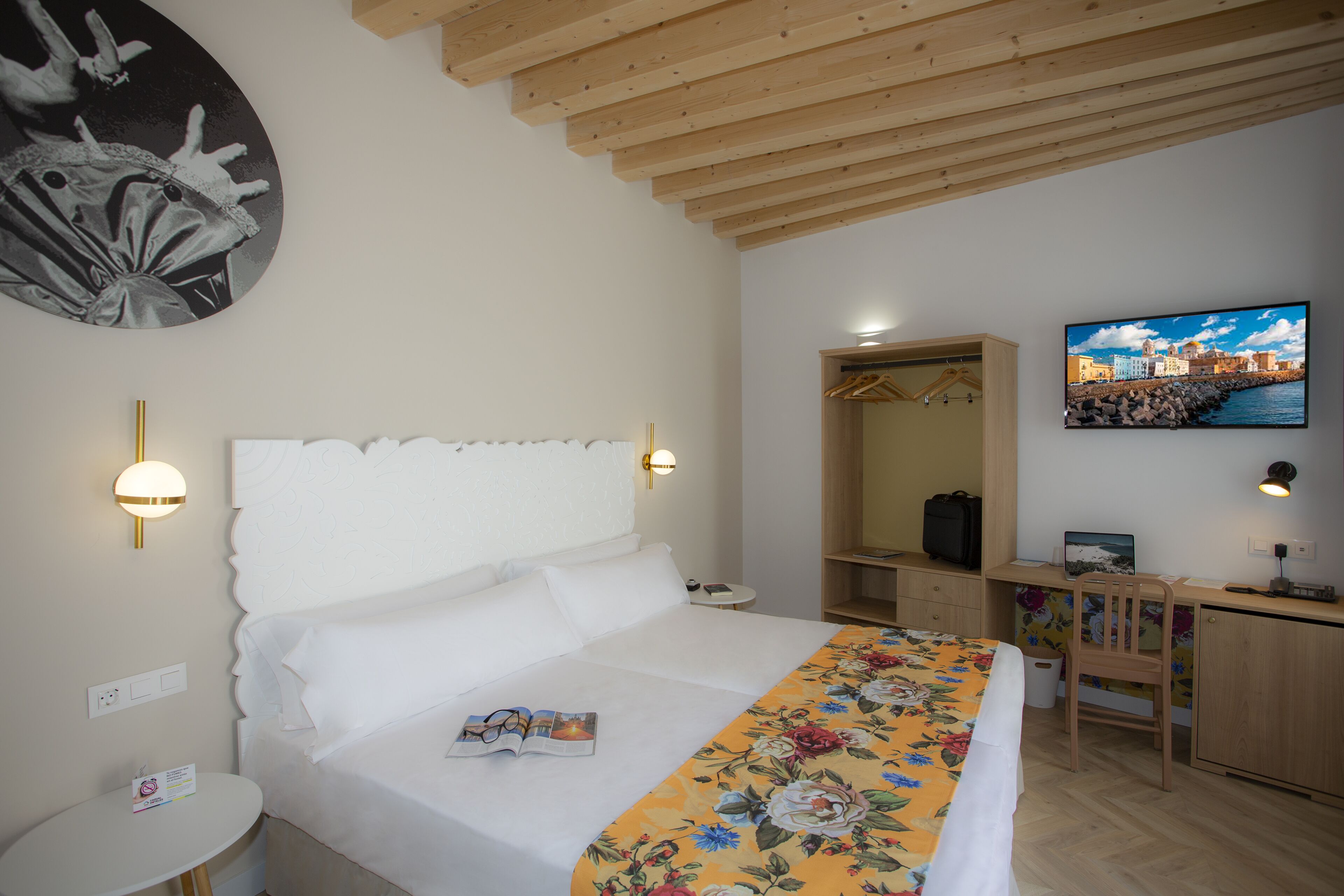 Un dormitorio con cama, mesita de noche y escritorio con silla.