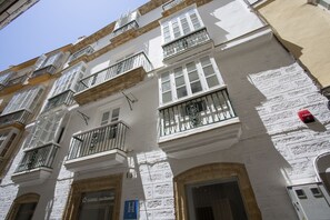 A multi-story building with white facades, multiple balconies with black railings, and a visible fire alarm. - Casual Con Duende Cádiz Hotel by Casual Hoteles (Cádiz)