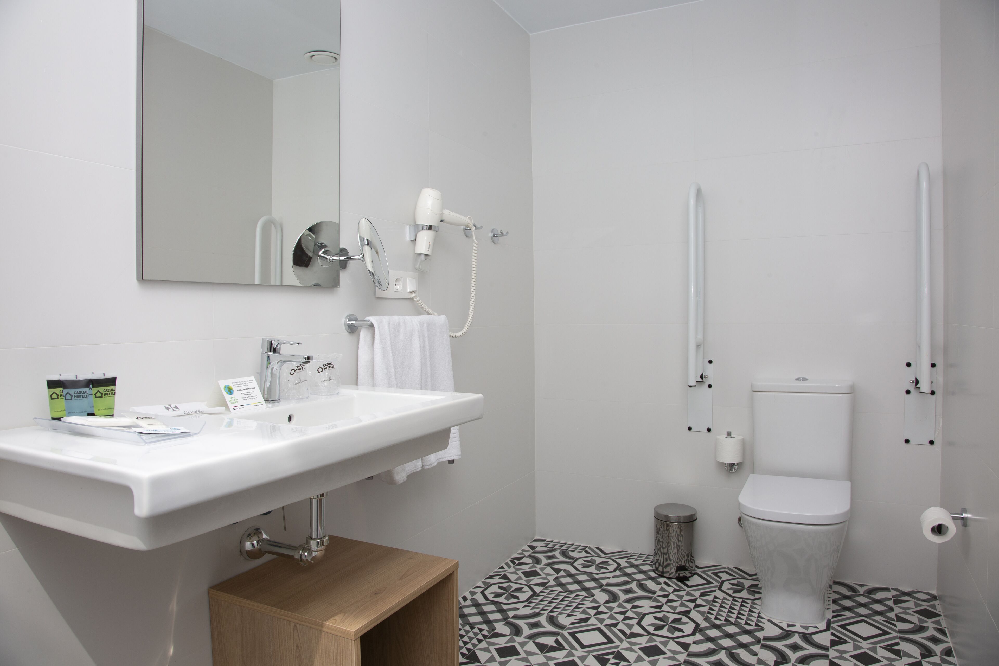 Une salle de bain moderne avec un lavabo blanc, un miroir et des toilettes.