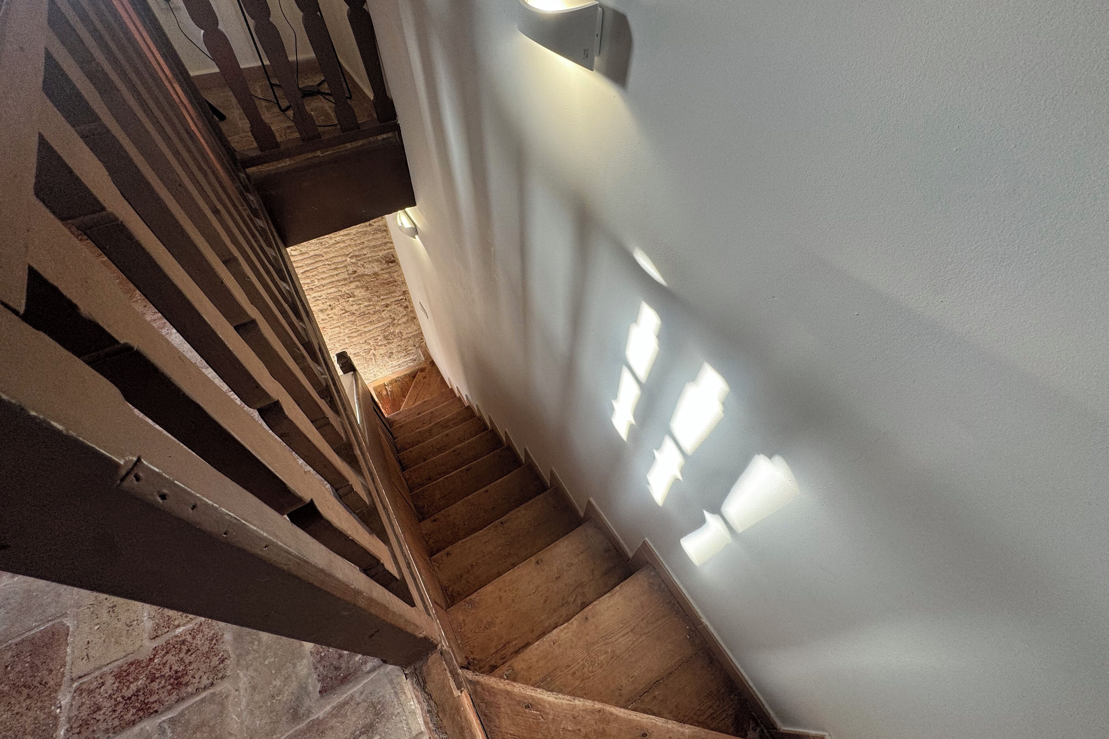Eine Treppe mit Holzboden und einer weißen Wand.