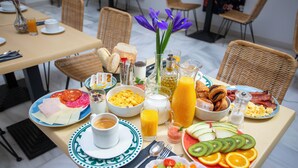 Una mesa de desayuno con diferentes alimentos, como frutas, pan y bebidas.