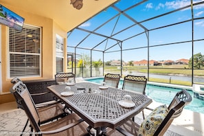 A covered patio with a pool view, outdoor seating, and a TV screen. - Spacious Pool Area With Lake View - 5bd/4.5ba Pool Home #5av139 (Davenport)