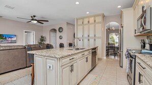 A spacious kitchen with a central island, built-in cabinets, and a dining area with a view. - Spacious Pool Area With Lake View - 5bd/4.5ba Pool Home #5av139 (Davenport)