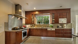 A modern kitchen with granite countertops, stainless steel appliances, and wooden cabinetry. - Villa Luz - Stunning 4-Bed Villa (Vilamoura)