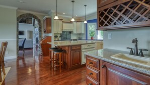 Una cocina amplia con armarios de madera, encimera de granito y lavavajillas integrado.
