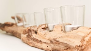 A row of clear glasses on a wooden surface. - Leystuuv (Krummhoern)