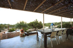 An outdoor patio with a table and chairs, a lantern, and potted plants. - Romero en Can Corda, Chalet 4 Dormitorios 4 Baños con piscina en Cap de Barbaria Formentera (Sant Francesc de Formentera)