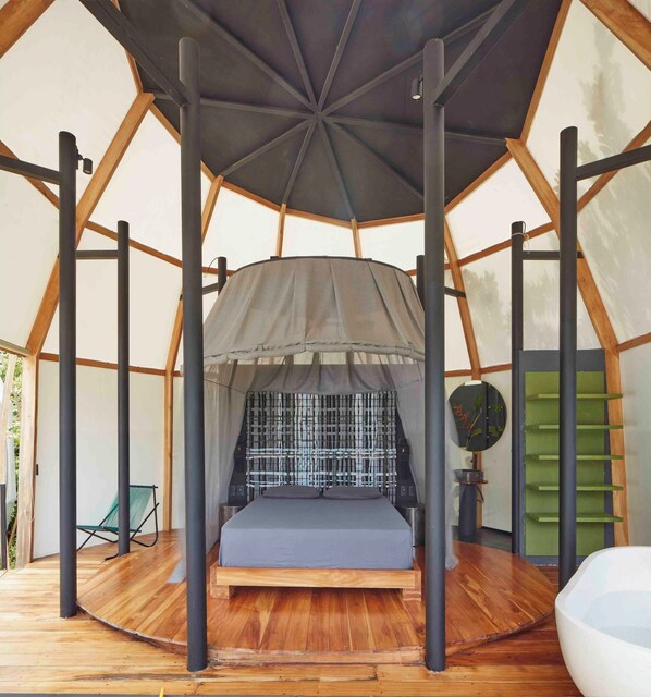 Una camera a tenda con un letto, un tavolino e una sedia.