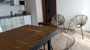 Una cocina moderna con una mesa de comedor de madera y dos sillas de mimbre.