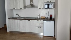 Una cocina moderna con armarios blancos, electrodomésticos de acero inoxidable y lavavajillas integrado.
