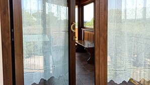 Una puerta de madera con paneles de vidrio esmerilado y un felpudo con una flecha.