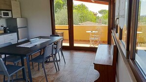 Una cocina con comedor, vistas al exterior y un balcón con mesa y sillas.