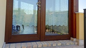 Una puerta de madera con un panel de vidrio y un picaporte metálico.
