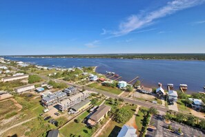An aerial view of a coastal town with residential buildings, a marina, and a large body of water. - Crystal Tower 1801 (Gulf Shores)