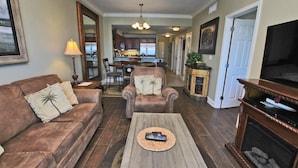 A living room with a sofa, armchairs, a coffee table, and a fireplace. - Crystal Tower 1205 by Youngs Suncoast (Gulf Shores)