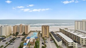A beachfront hotel with multiple buildings, a parking lot, and a swimming pool. - Crystal Tower 1507 (Gulf Shores)