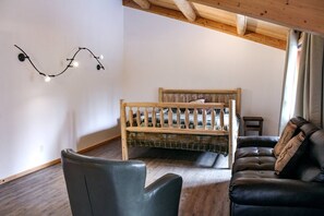 A cozy room with a wooden bed, a leather sofa, and a small table.