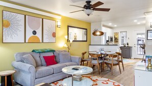 A living room with a grey sofa, a round coffee table, and a dining area with wooden chairs and a table. - Outpost: Pitchfork 452 - Close to Snow King Mtn! (Jackson)