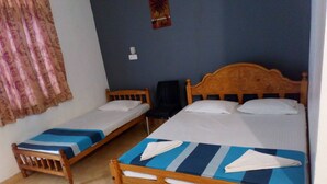 A room with two wooden beds, each with a blue and white striped bedspread and white pillows. - Nilaveli Hotel Onethra (Trincomalee)