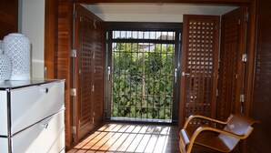 A room with a wooden floor, a brown chair, and a white cabinet. - House with garden and views in a natural area 15' from the bustling city center (Granada)