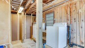 Un interior de madera con un refrigerador blanco, vigas de madera y una ventana.