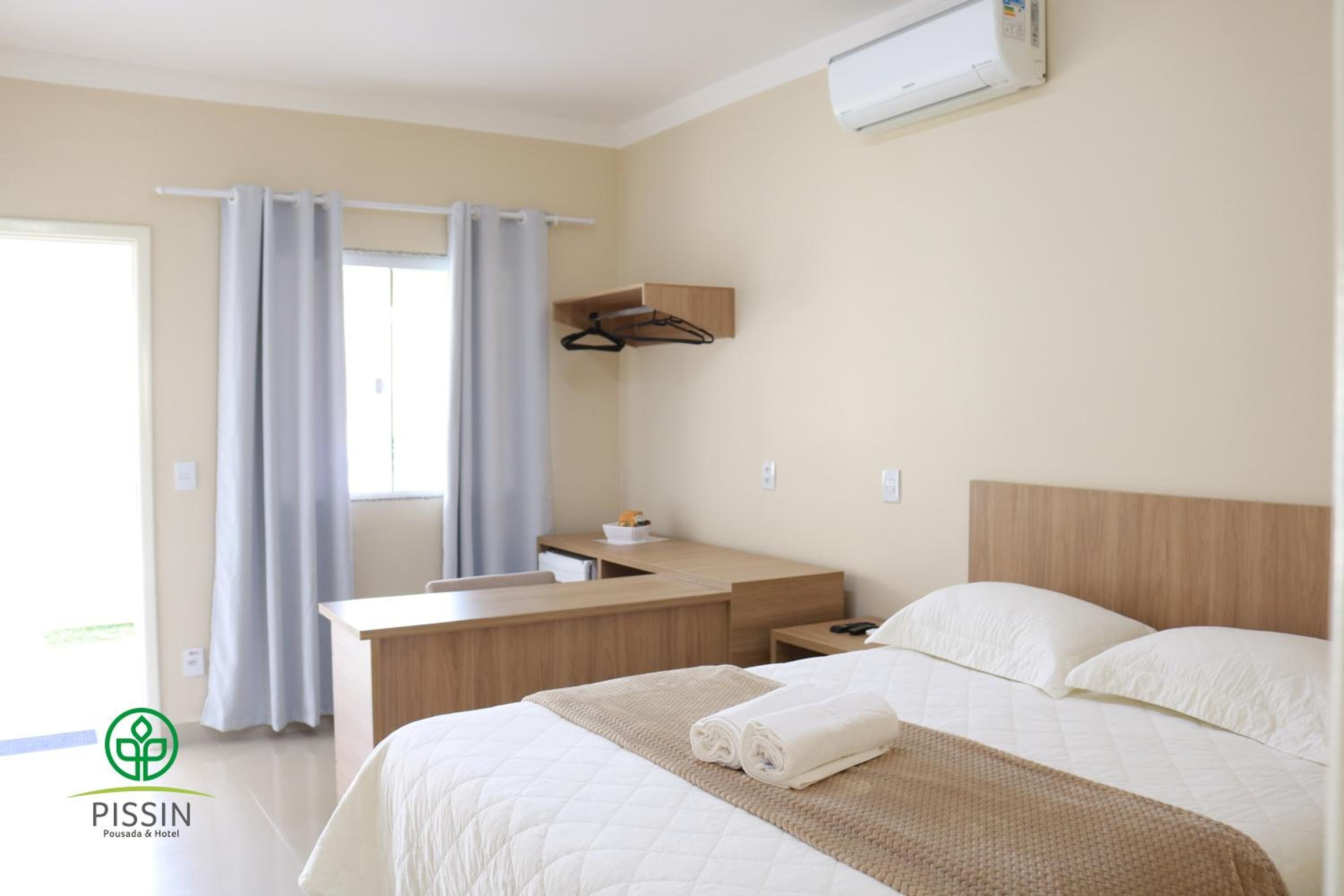 A hotel room with a bed, a desk, and a bathroom.