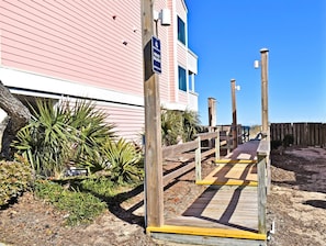 A wooden boardwalk leading to a building with a sign indicating a private walkway.