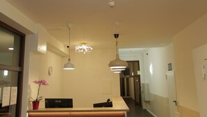 Cozinha moderna com ilha central, luminárias pendentes e geladeira.