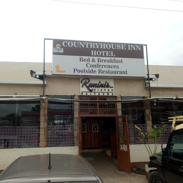 A Countryhouse Inn Hotel with a sign indicating it offers bed & breakfast, conferences, and a poolside restaurant. - Countryhouse Inn Hotel (Naivasha)
