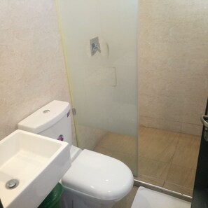 A bathroom with a toilet, sink, and shower stall. - Countryhouse Inn Hotel (Naivasha)