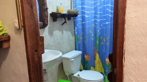 Ein Badezimmer mit Toilette, Bidet und Ablage für Toilettenartikel.
