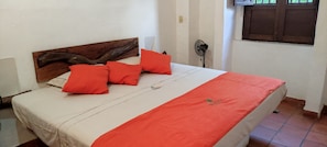 Un lit avec une tête de lit en bois, des oreillers rouges et une couvre-lit rouge.