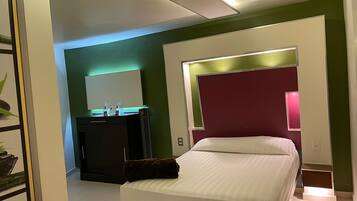 Una habitación de hotel moderna con una cama, un escritorio y un espejo.