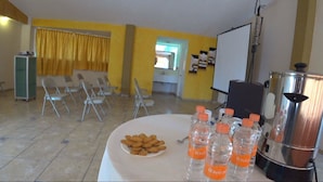 A conference room with a white table, chairs, a projector, and a water dispenser. - Hotel Cuandón (Tepeji del Río de Ocampo)
