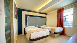 A hotel room with two single beds, a large mirror, a window with red curtains, and a tiled floor. - Hotel Cuandón (Tepeji del Río de Ocampo)