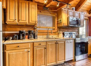 A kitchen with wooden cabinets, a coffee maker, a stove, and a dishwasher.