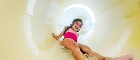 A person in a water slide with a circular tunnel.