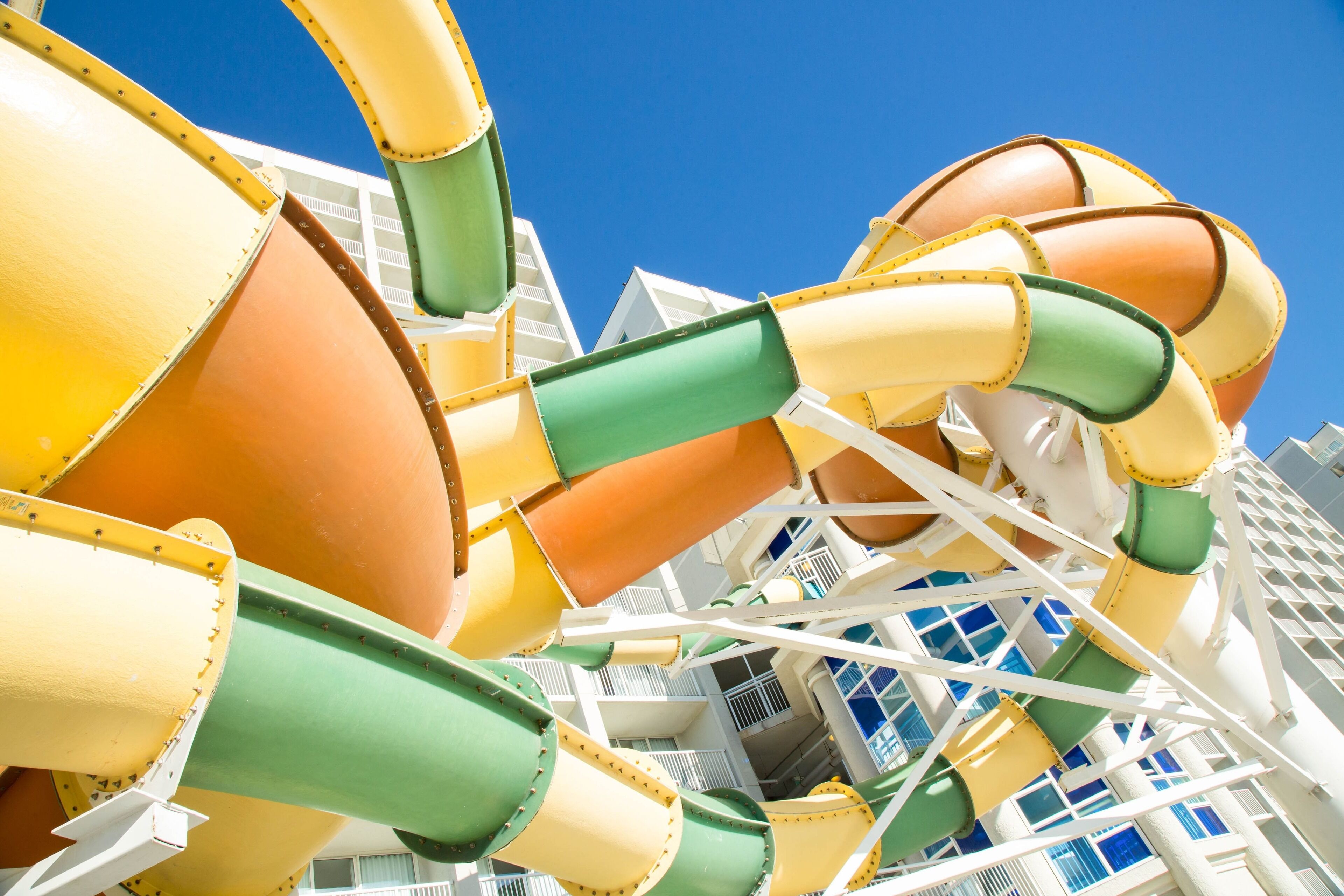 A water slide structure with multiple lanes and a clear blue sky in the background.