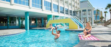 A swimming pool area with a building in the background.
