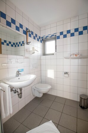 Een douche, een haardroger, handdoeken, toiletpapier