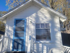 A small white building with a blue door and a window with blinds. - 2 River Road Inn and Cottages (Cape Neddick)
