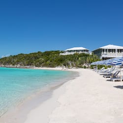 Na praia, espreguiçadeiras, guarda-sóis, toalhas de praia