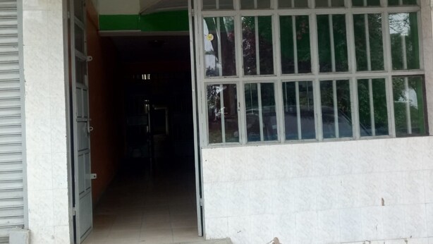 A building entrance with a tiled floor, a green and white wall, and a large window with white frames. - Epco Guest House (Naivasha)