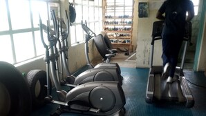 A gym with exercise equipment, a treadmill, and a shoe rack. - Epco Guest House (Naivasha)