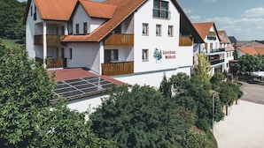 Um hotel com fachada branca, várias varandas e uma placa com a inscrição "Gästehaus Waldeck".