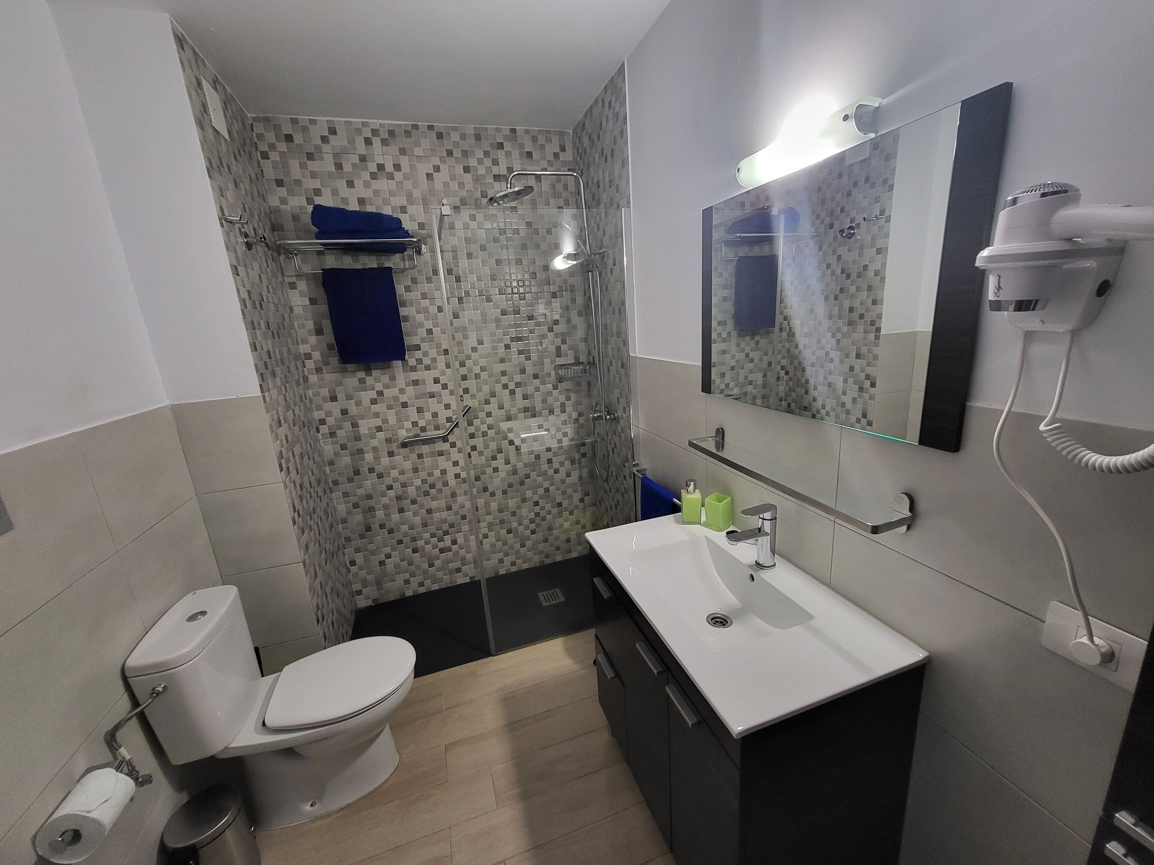 Un bagno moderno con servizi igienici, lavandino e doccia.