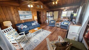 L’intérieur d’un chalet chaleureux, avec un canapé bleu, une table à manger et un coin cuisine.